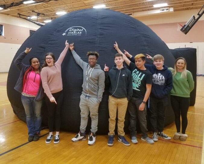 Students stand in front of StarLab inflatable planetarium